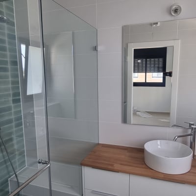 מקלחת עם דלת זכוכית וראש מקלחת עגול