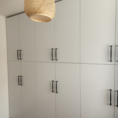 ארונות מטבח לבנים עם ידיות שחורות ותאורה תלויה