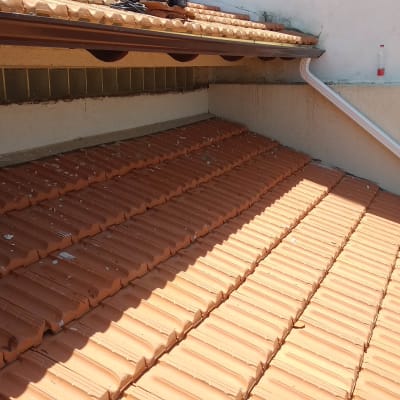 רעפים כתומים על גג עם מרזב לבן