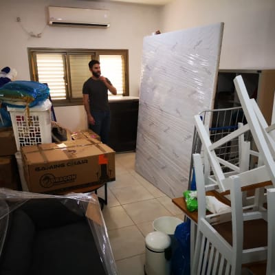 חפצים ארוזים למעבר דירה, כולל קרטונים ומזרן