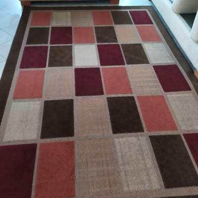 שטיח מרובע עם דוגמאות צבעוניות על רצפה