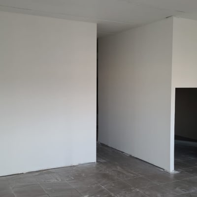 קירות צבועים בלבן בחדר ריק עם רצפה אפורה
