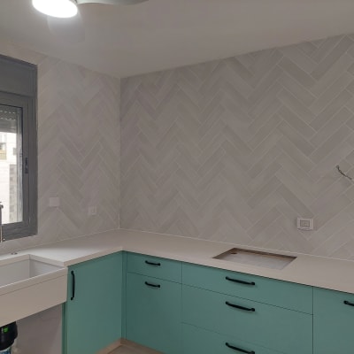 מטבח בשיפוץ עם אריחים חדשים וברז מותקן