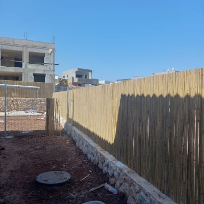 אדמה חפורה, מריצה וכלי גינון ליד גדר במבוק