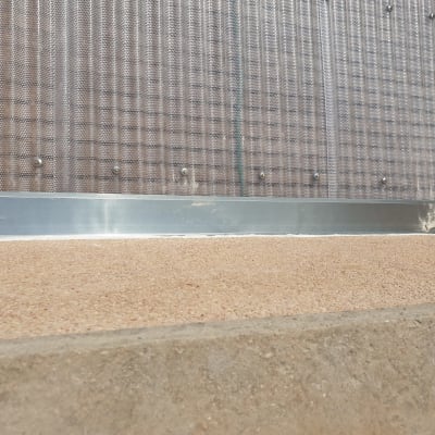 קיר מתכת עם ברגים מעל משטח עץ