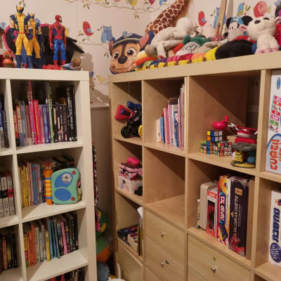 מדפים עם צעצועים, ספרים וקופסאות משחקים מסודרים
