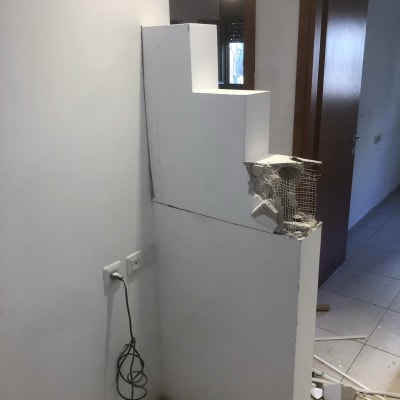 קיר לבן עם חור ותשתית רשת מתכת