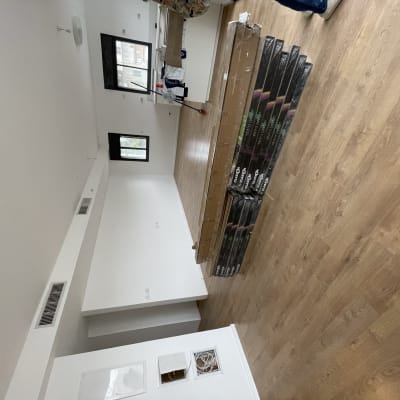 חבילות פרקט מונחות על רצפת עץ בחדר ריק