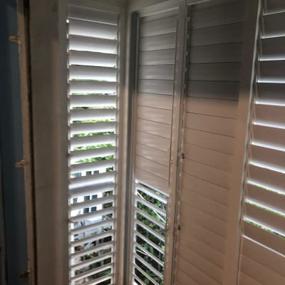 תריסי אלומיניום לבנים בחלון פינה