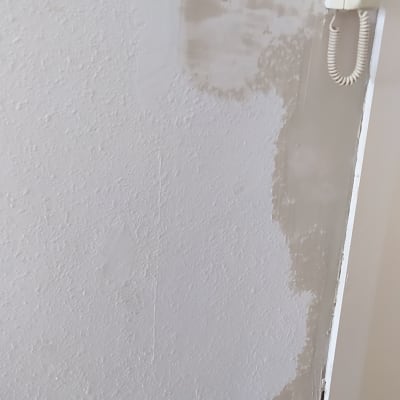 קיר עם תיקוני צבע וטיח חלקי