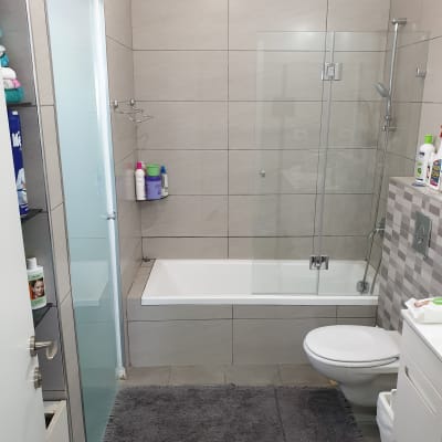 מקלחת עם אמבטיה, וילון זכוכית ומוצרי טיפוח