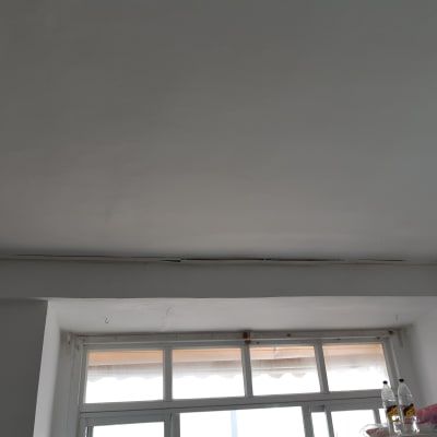 תקרה עם סדקים ליד חלון, בקבוקי שתייה על מדף