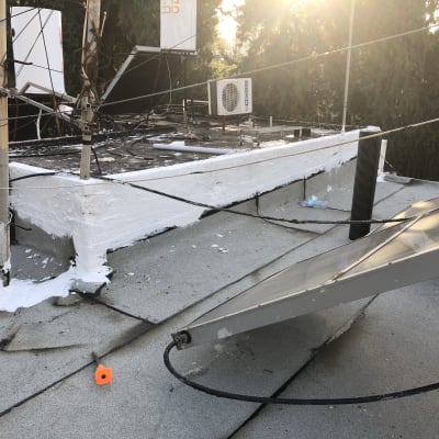 איטום גג עם חומר לבן סביב צינורות