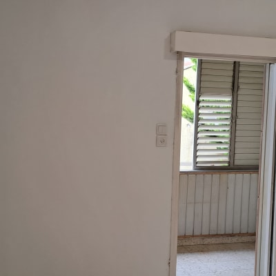 קיר לבן עם דלת הזזה וחלון פתוח