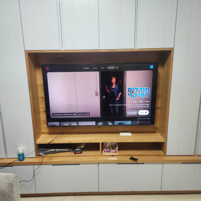 טלוויזיה מותקנת בארון עץ עם מדפים