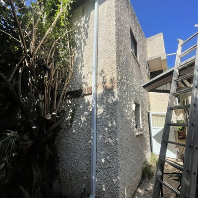 מרזב לבן מחובר לגג בית