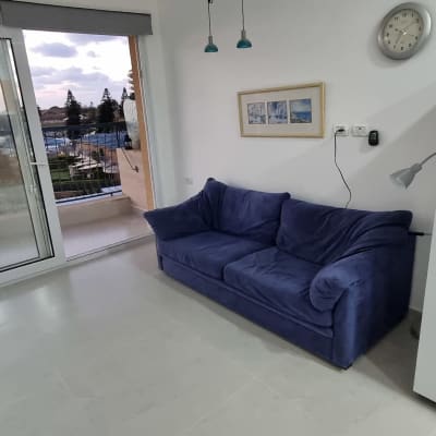 סלון עם ספה, מקרר ודלת זכוכית למרפסת