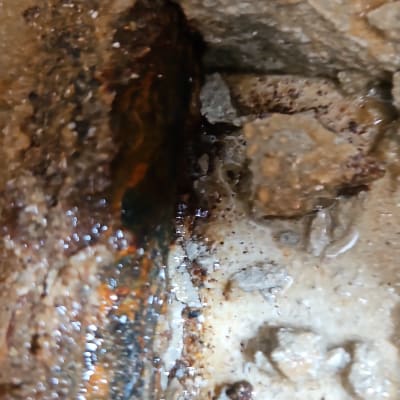 נזילת מים על צינור חלוד בתוך קיר