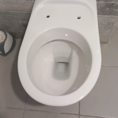 אסלה לבנה על רצפת אריחים אפורה