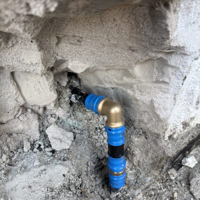 צינור מים מותקן בקיר בטון