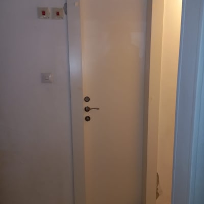 דלת לבנה עם ידית כסופה ומסגרת פשוטה