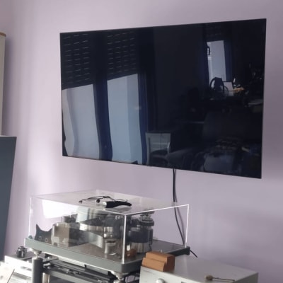 טלוויזיה מותקנת על קיר עם רמקולים ומערכת סטריאו