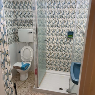 חדר אמבטיה עם מקלחת, שירותים וכיור כחול