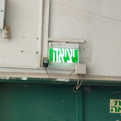 שלט יציאה מואר עם חוטי חשמל גלויים