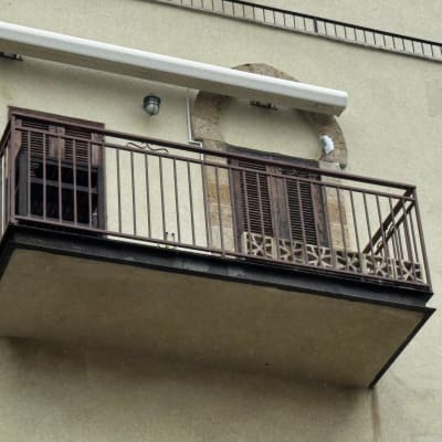 מרפסת עם מעקה ברזל על קיר בניין