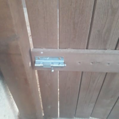 בריח מתכת מותקן על שער עץ חום