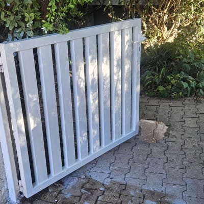שער מתכת לבן בכניסה לגינה