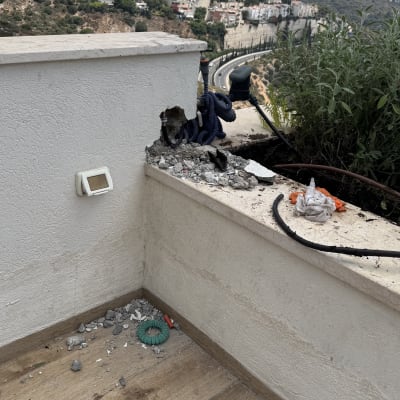 פינת מרפסת עם צינורות חשופים ונוף עירוני
