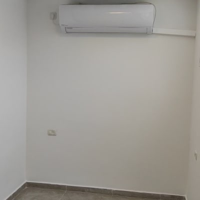 A small empty room with white walls and a ceiling light.