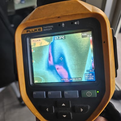 מד חום תרמי מציג תמונה צבעונית של אזור עם טמפרטורה.