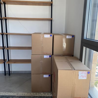 קופסאות קרטון מסודרות ליד מדפים ריקים