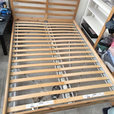 מיטה מעץ עם מסגרת מתכת בחדר שינה