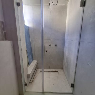 תא מקלחת עם דלת זכוכית וברזים