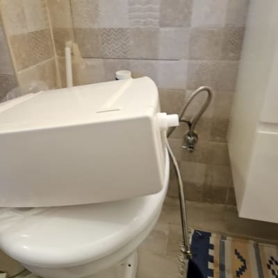 אסלה עם מיכל מים מנותק וצינור גמיש