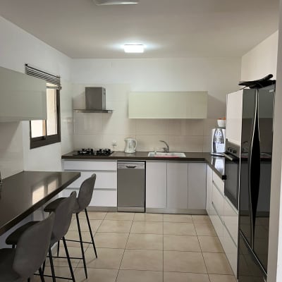 מטבח מודרני עם כיסאות בר, כיור ותנור