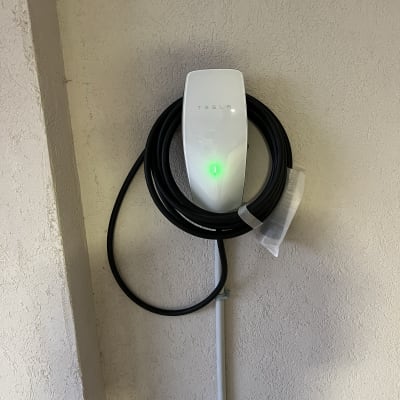 מטען טסלה עם כבל שחור על קיר