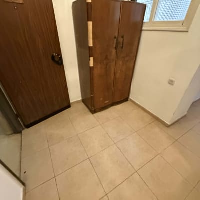 ארון עץ ליד דלת וחלון בחדר ריק