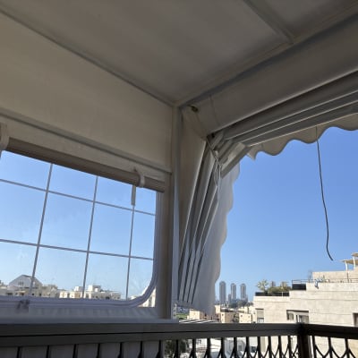 מרפסת עם סוכך נגלל ונוף עירוני