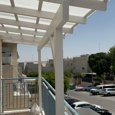 פרגולה מעץ במרפסת עם נוף עירוני