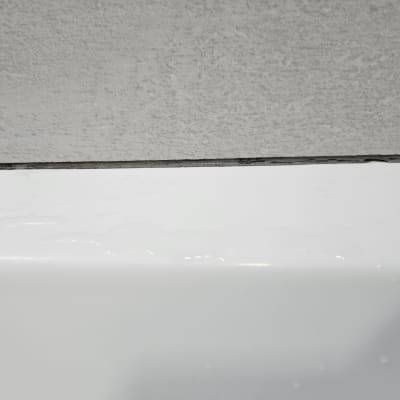 רטיבות על משטח לבן ליד קיר אפור