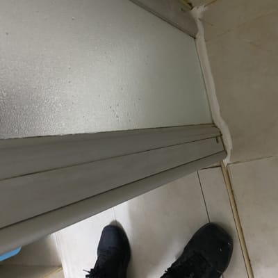 דלת מקלחת עם ריצוף קרמיקה ורגליים של אדם