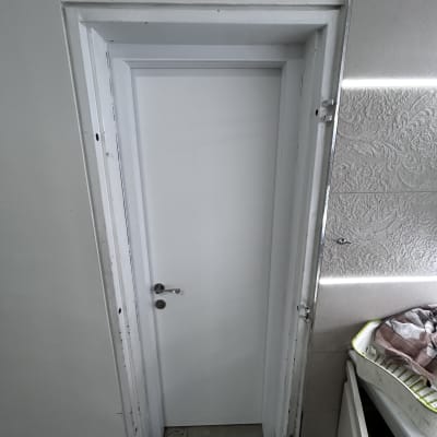 דלת לבנה עם ידית מתכת בחדר