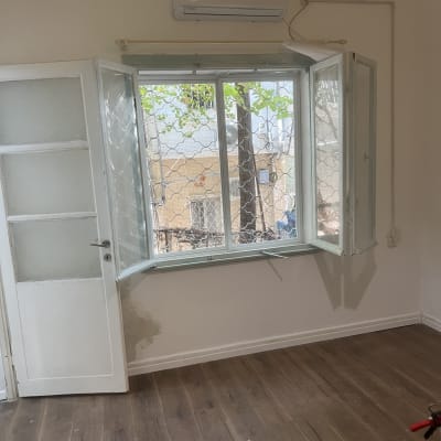 חלון אלומיניום פתוח עם סורג בחדר ריק