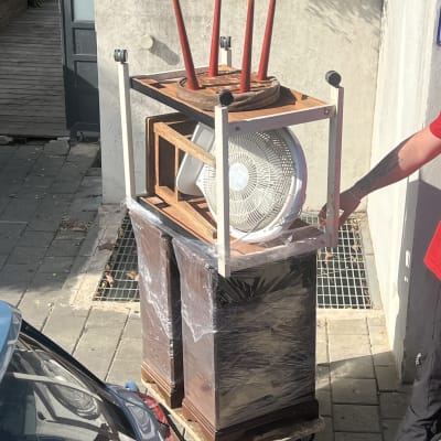 ציוד ארוז על עגלה, כולל מאוורר וכיסאות, מוכן להובלה
