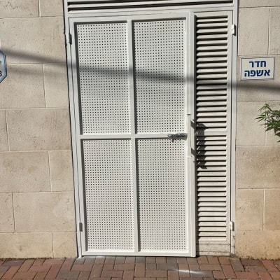 דלת מתכת עם חורים על קיר חיצוני