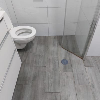 רצפת חדר אמבטיה נקייה עם אריחים אפורים